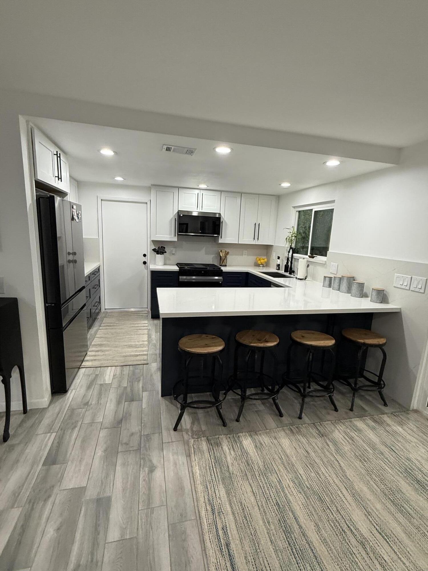 37081 Palmdale Road Rancho Mirage, CA 92270 - Photo 18 of 46 a kitchen with a table chairs refrigerator and a counter top space