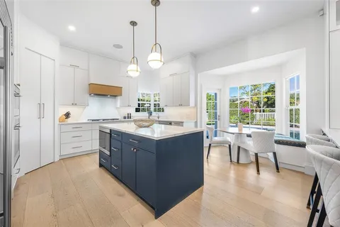 a large white kitchen with a table and chairs