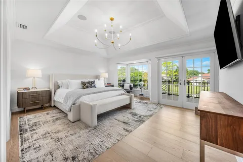 a bedroom with a bed flat screen tv and a large window