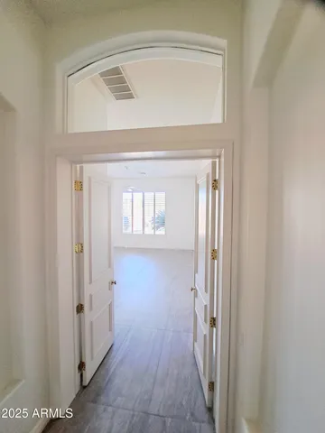 a view of a hallway with wooden floor and staircase
