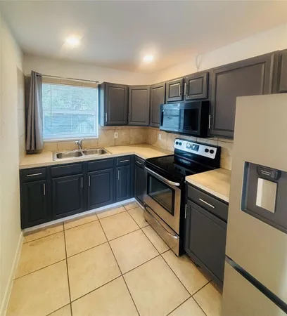 a kitchen with stainless steel appliances granite countertop a sink and a stove