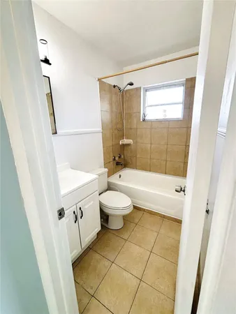 a bathroom with a bathtub shower sink vanity mirror and toilet