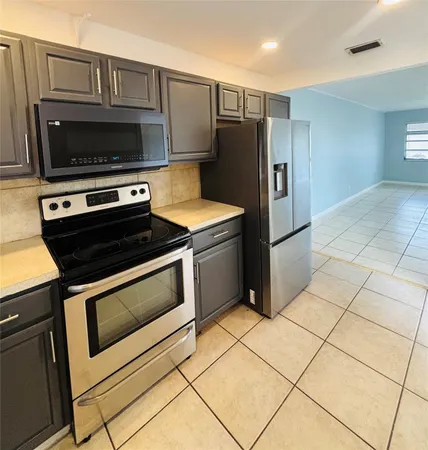 a kitchen with granite countertop a stove and a microwave