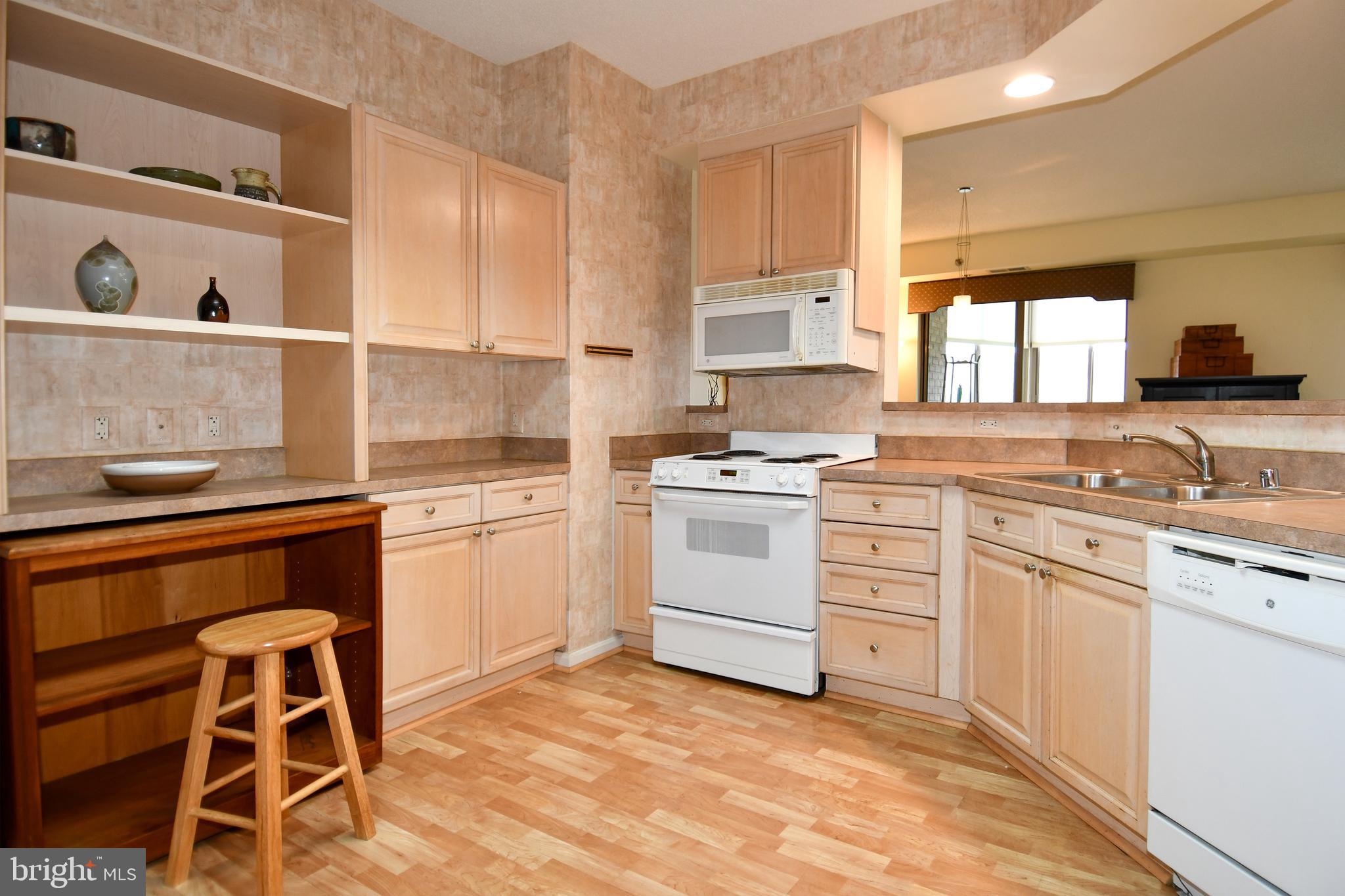 3210 North Leisure World Boulevard, Unit 519 Silver Spring, MD 20906 - Photo 13 of 64 a kitchen with white cabinets and white appliances