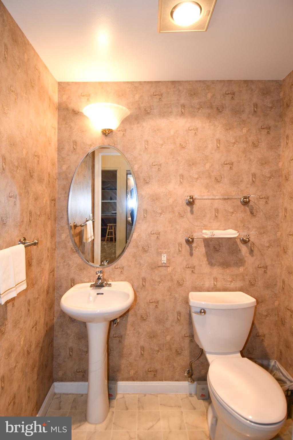 3210 North Leisure World Boulevard, Unit 519 Silver Spring, MD 20906 - Photo 17 of 64 a bathroom with a toilet sink and mirror