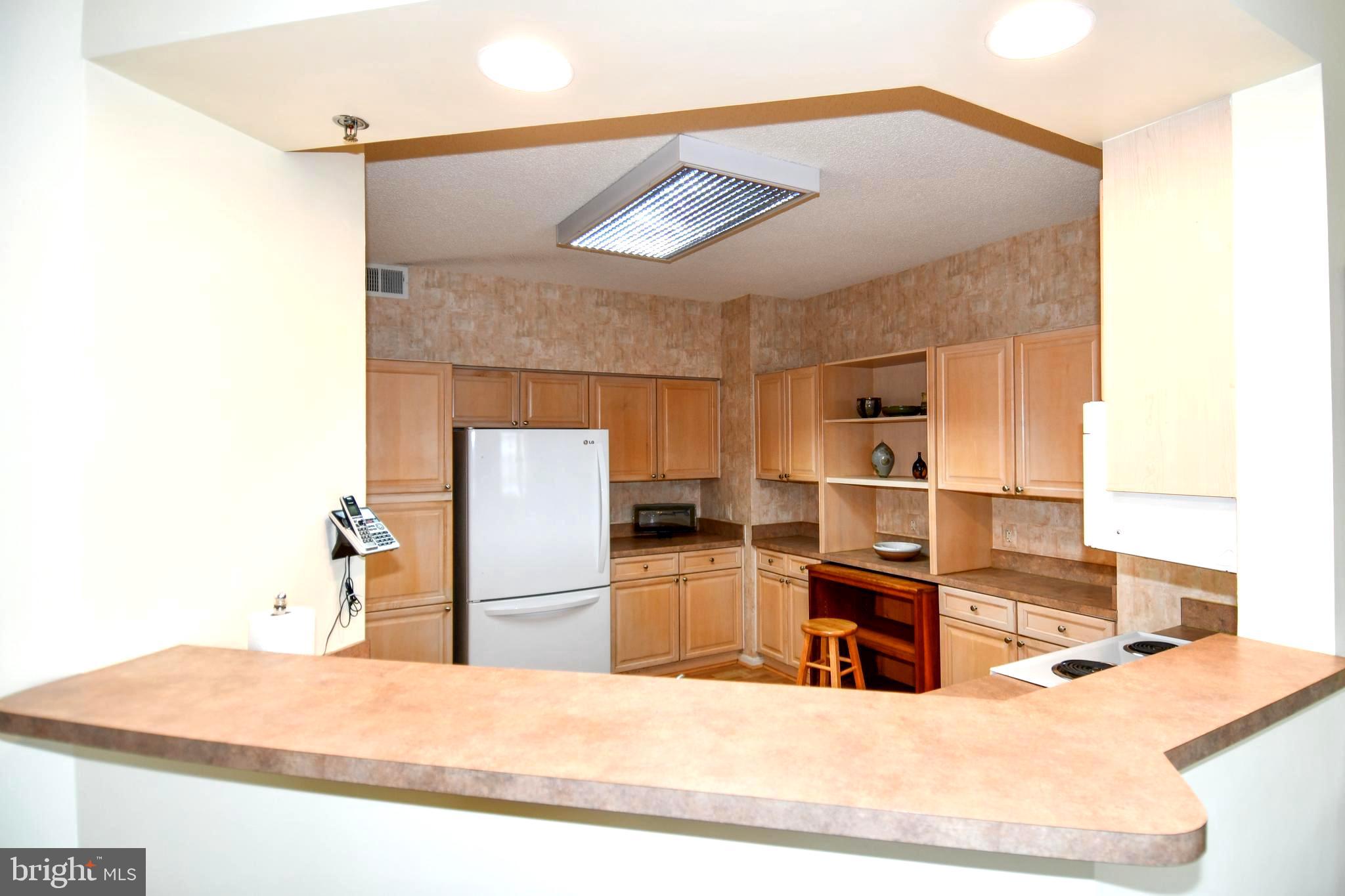 3210 North Leisure World Boulevard, Unit 519 Silver Spring, MD 20906 - Photo 2 of 64 a kitchen with kitchen island a counter top space cabinets stainless steel appliances and a counter top space