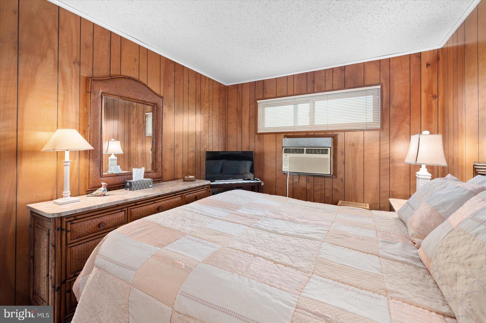 12 128th Street, Unit 2 Ocean City, MD 21842 - Photo 21 of 40 a bedroom with a bed and a dresser with mirror