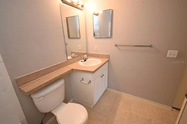 a bathroom with a granite countertop sink a toilet and shower