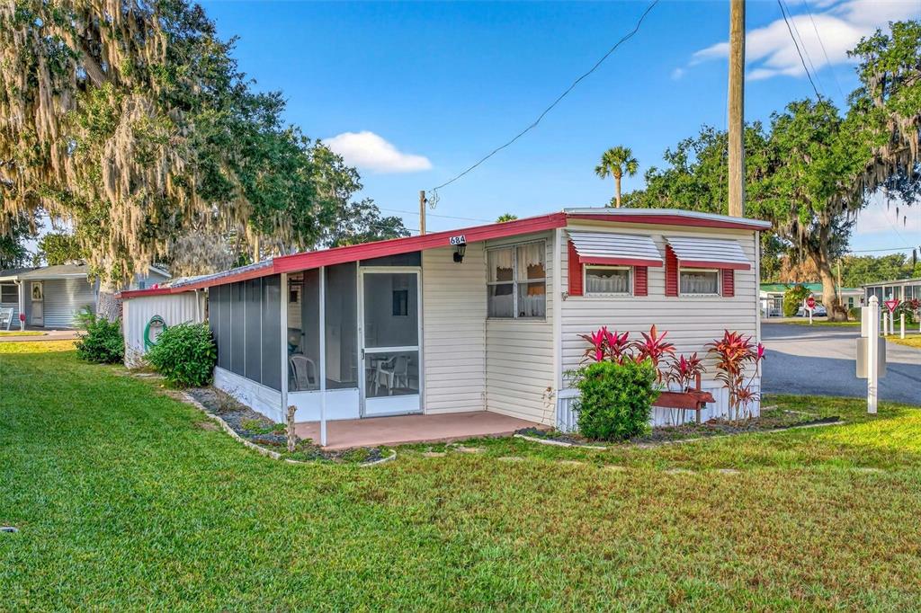 a view of a house with a yard and potted plants