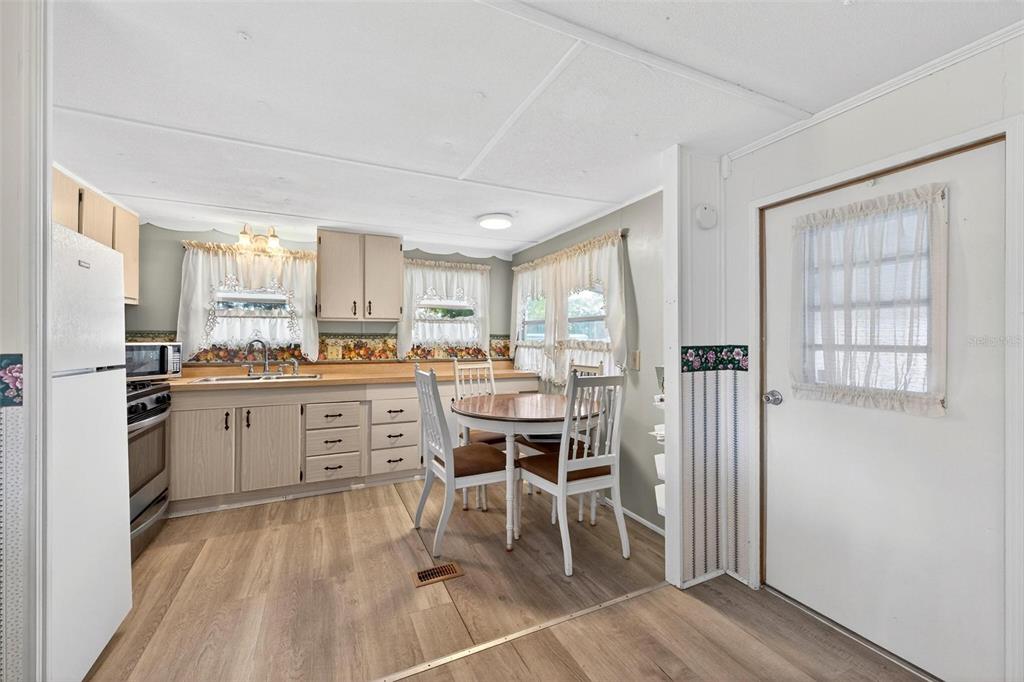 684 Cindi Avenue Leesburg, FL 34788 - Photo 14 of 60 a kitchen with a table chairs refrigerator and cabinets