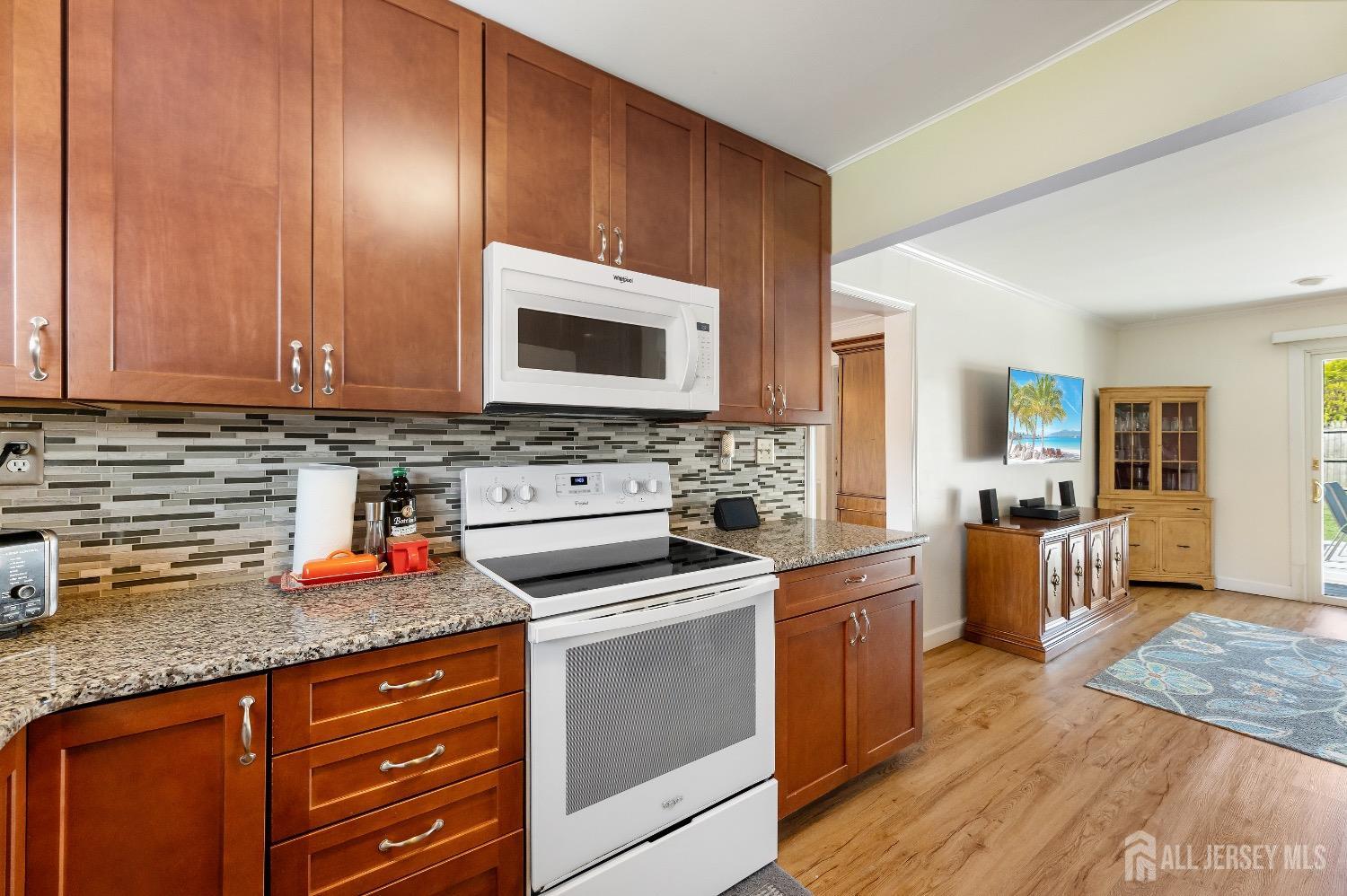 9 Pine Tree Road Old Bridge, NJ 08857 - Photo 21 of 46 a kitchen with stainless steel appliances granite countertop a stove top oven a sink dishwasher and cabinets with wooden floor