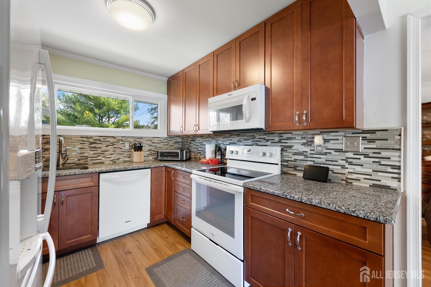 9 Pine Tree Road Old Bridge, NJ 08857 - Photo 23 of 46 a kitchen with stainless steel appliances granite countertop wooden cabinets a stove a sink and a microwave