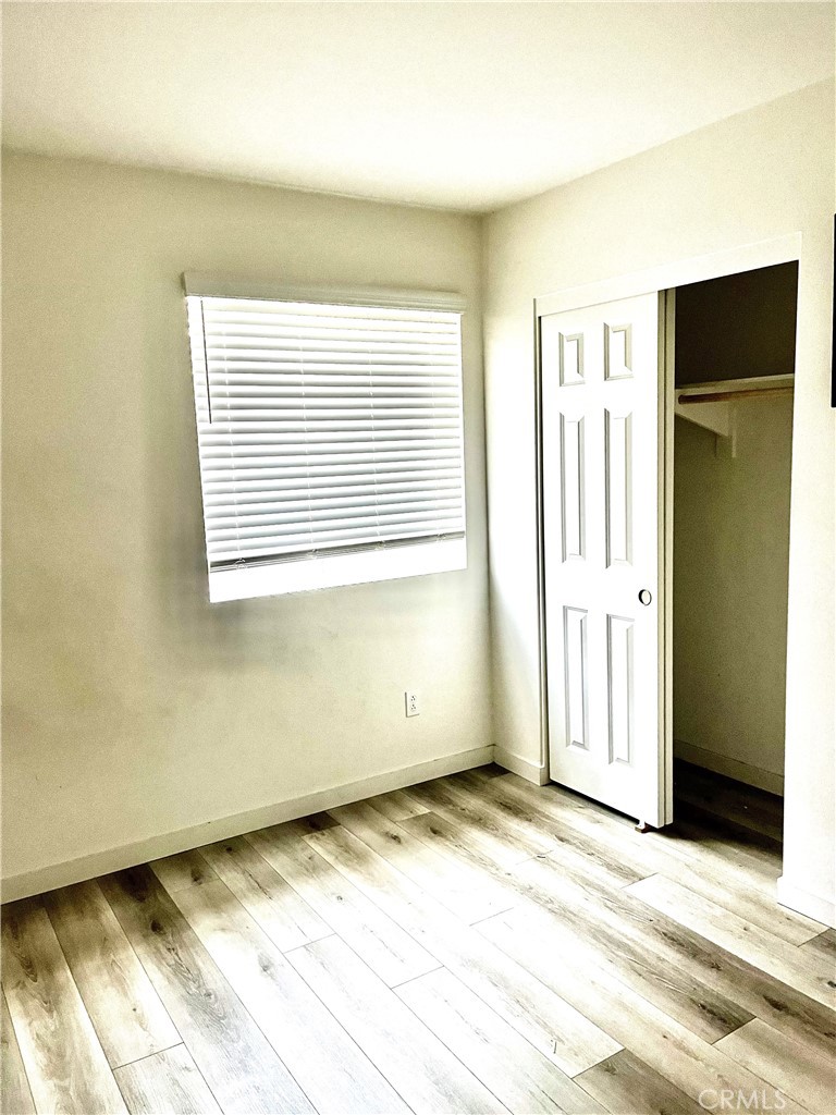 4255 Vermillion Court Riverside, CA 92505 - Photo 14 of 20 a view of an empty room with wooden floor and a window