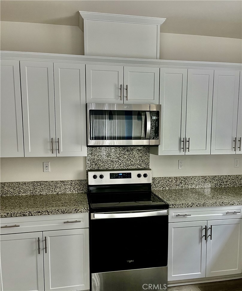4255 Vermillion Court Riverside, CA 92505 - Photo 5 of 20 a kitchen with granite countertop white cabinets and stainless steel appliances