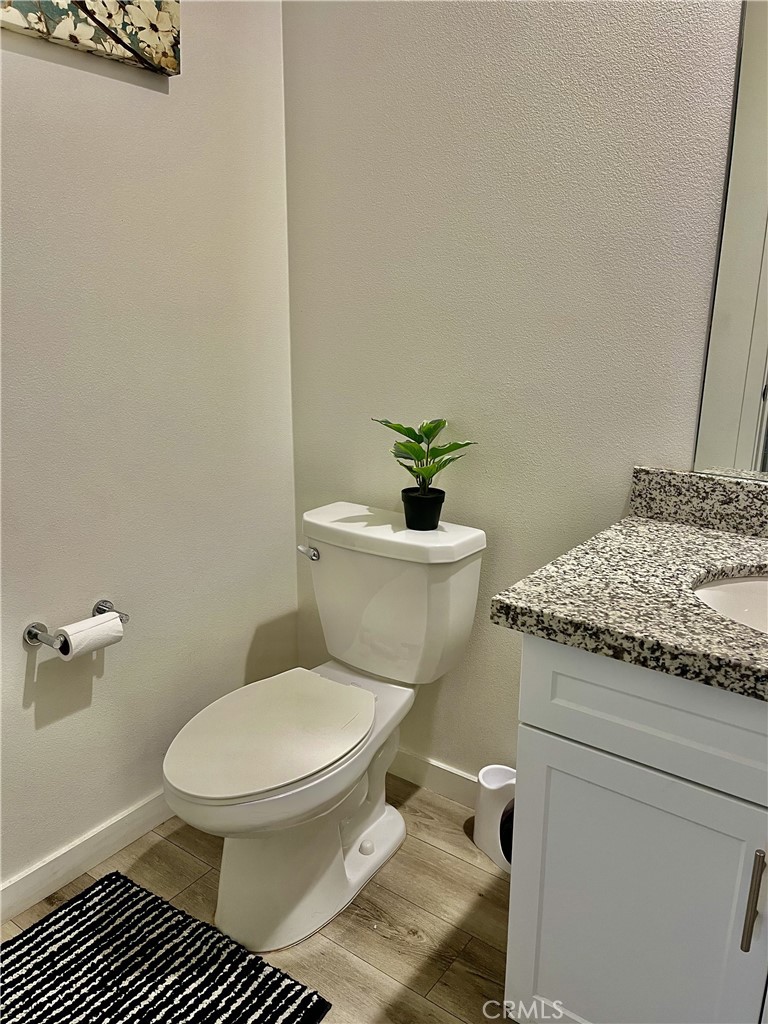 4255 Vermillion Court Riverside, CA 92505 - Photo 8 of 20 a white toilet sitting next to a bathroom sink and vanity