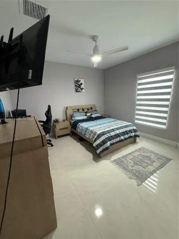 a bedroom with a bed a lamp and window