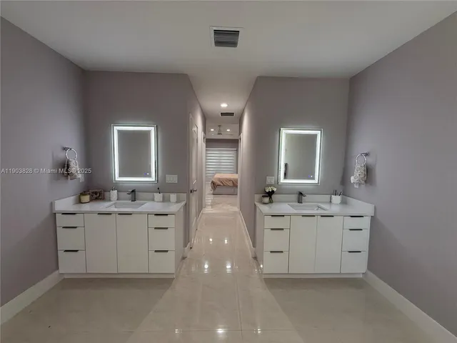 a spacious bathroom with a granite countertop sink double and mirror