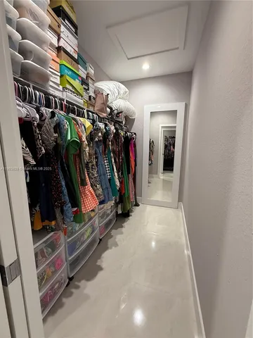 a view of walk in closet with clothes