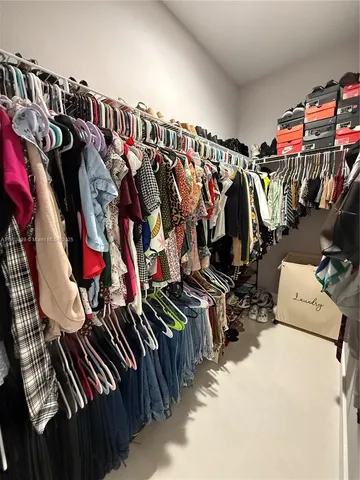 a view of walk in closet with clothes
