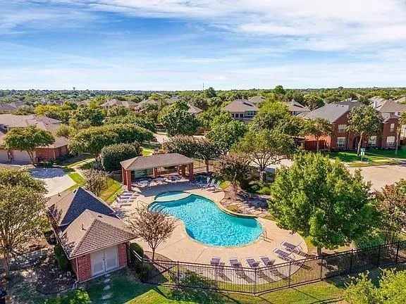 an aerial view of residential houses with outdoor space and trees