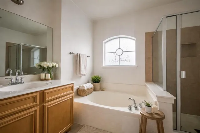 a bathroom with a tub sink and mirror