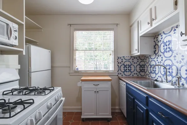 a kitchen with stainless steel appliances granite countertop a refrigerator and a stove with wooden floor