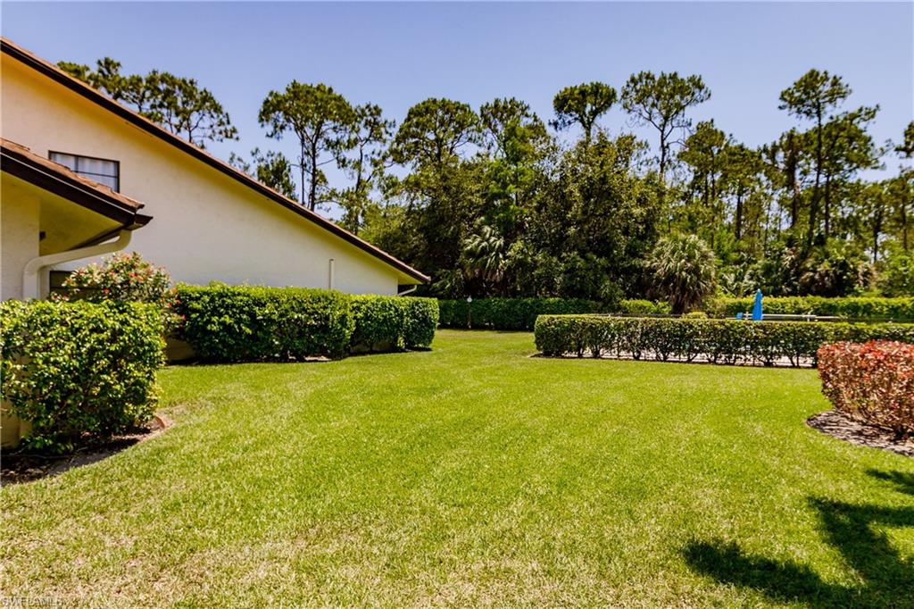 2118 Buckingham Lane Naples, FL 34112 - Photo 40 of 41 a backyard of a house with lots of green space and garden