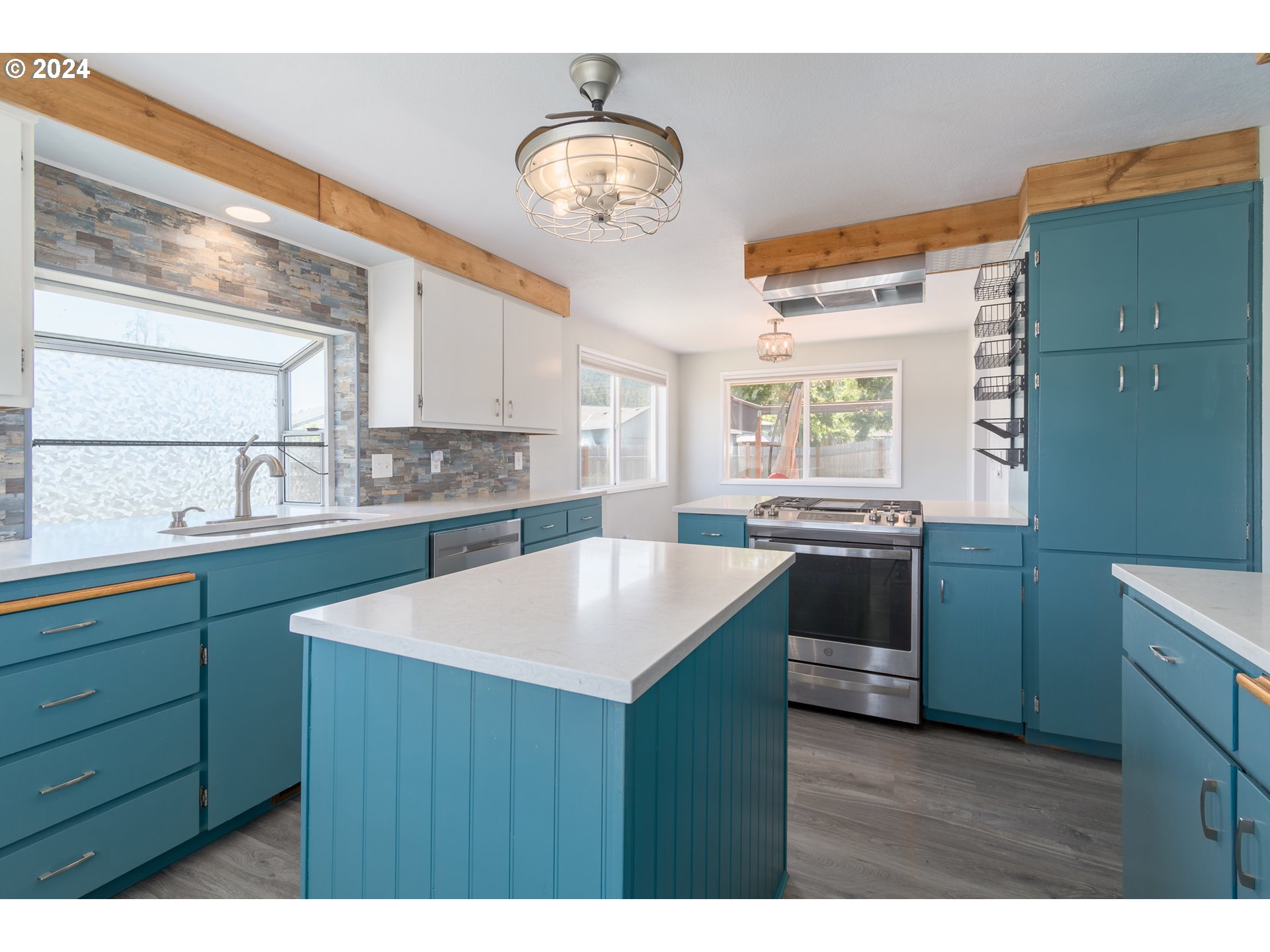 7345 B Street Springfield, OR 97478 - Photo 13 of 48 a kitchen with a sink cabinets a window and a counter