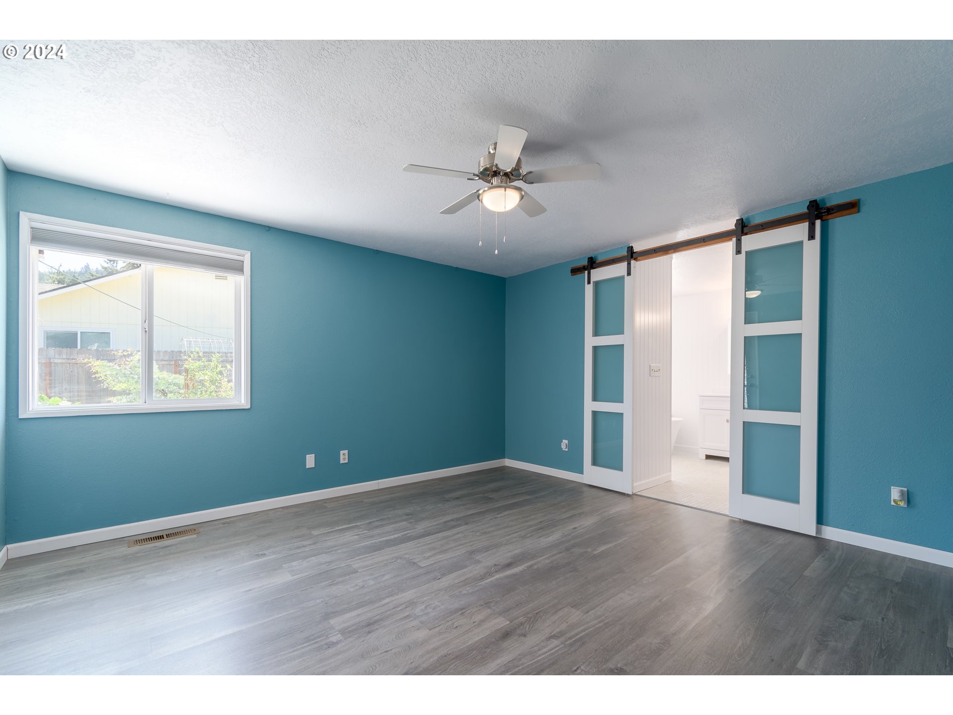 7345 B Street Springfield, OR 97478 - Photo 18 of 48 a view of an empty room with a window and wooden floor