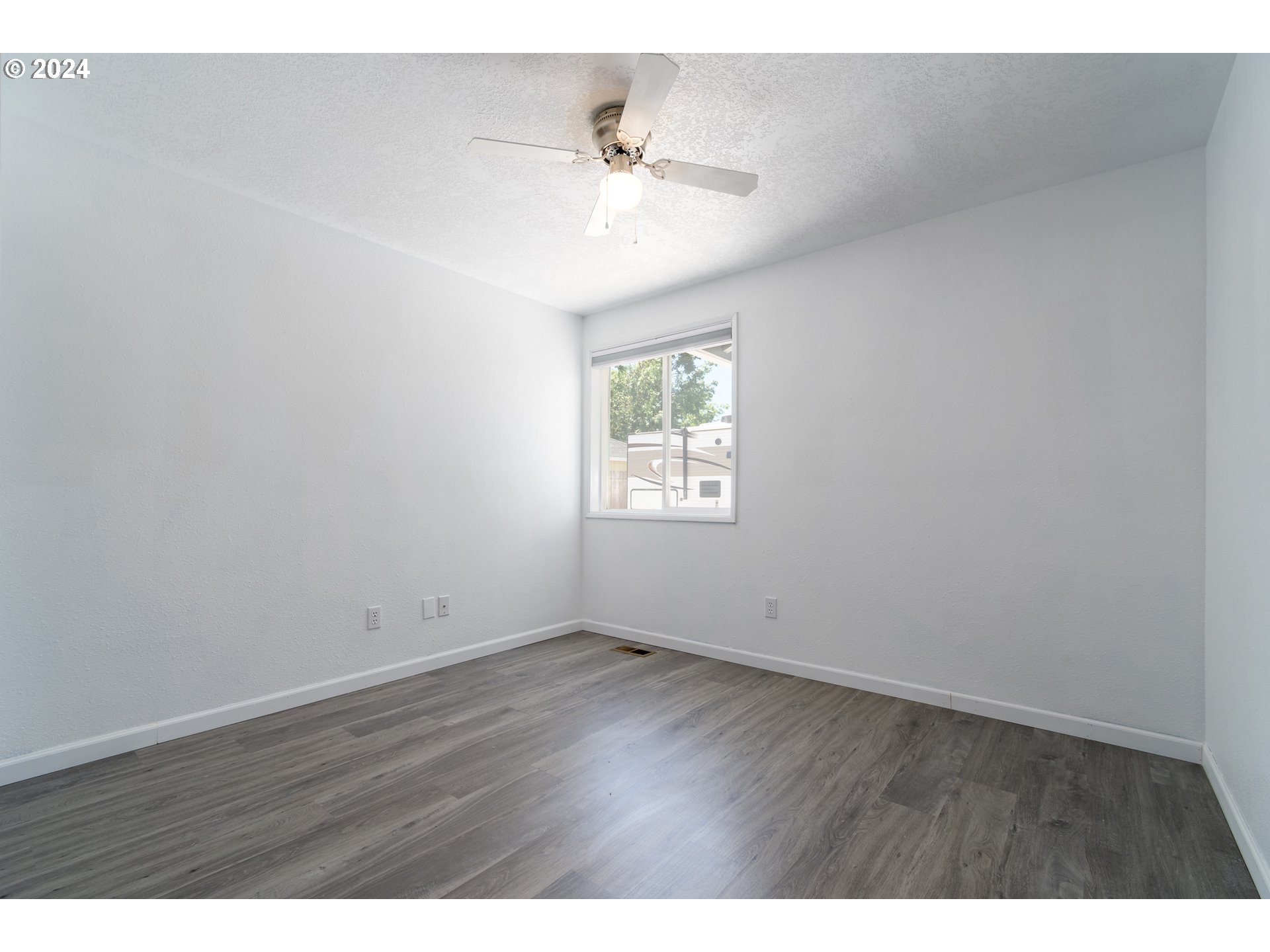 7345 B Street Springfield, OR 97478 - Photo 24 of 48 an empty room with wooden floor ceiling fan and windows