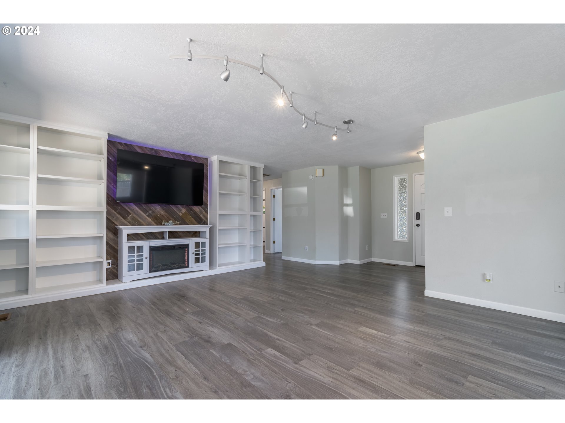 7345 B Street Springfield, OR 97478 - Photo 5 of 48 a view of an empty room with a fireplace and a ceiling fan