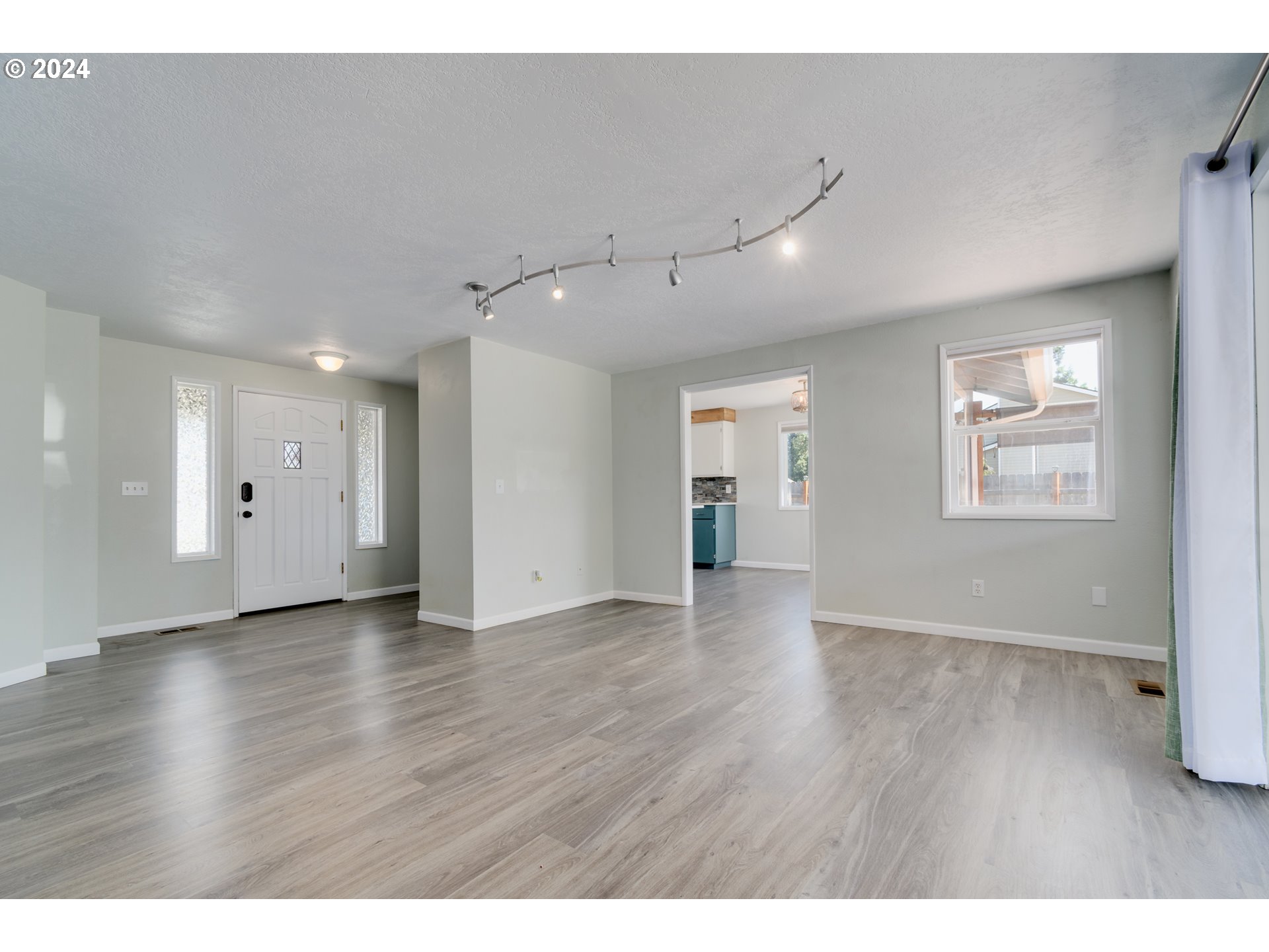 7345 B Street Springfield, OR 97478 - Photo 6 of 48 a view of an empty room with wooden floor and windows