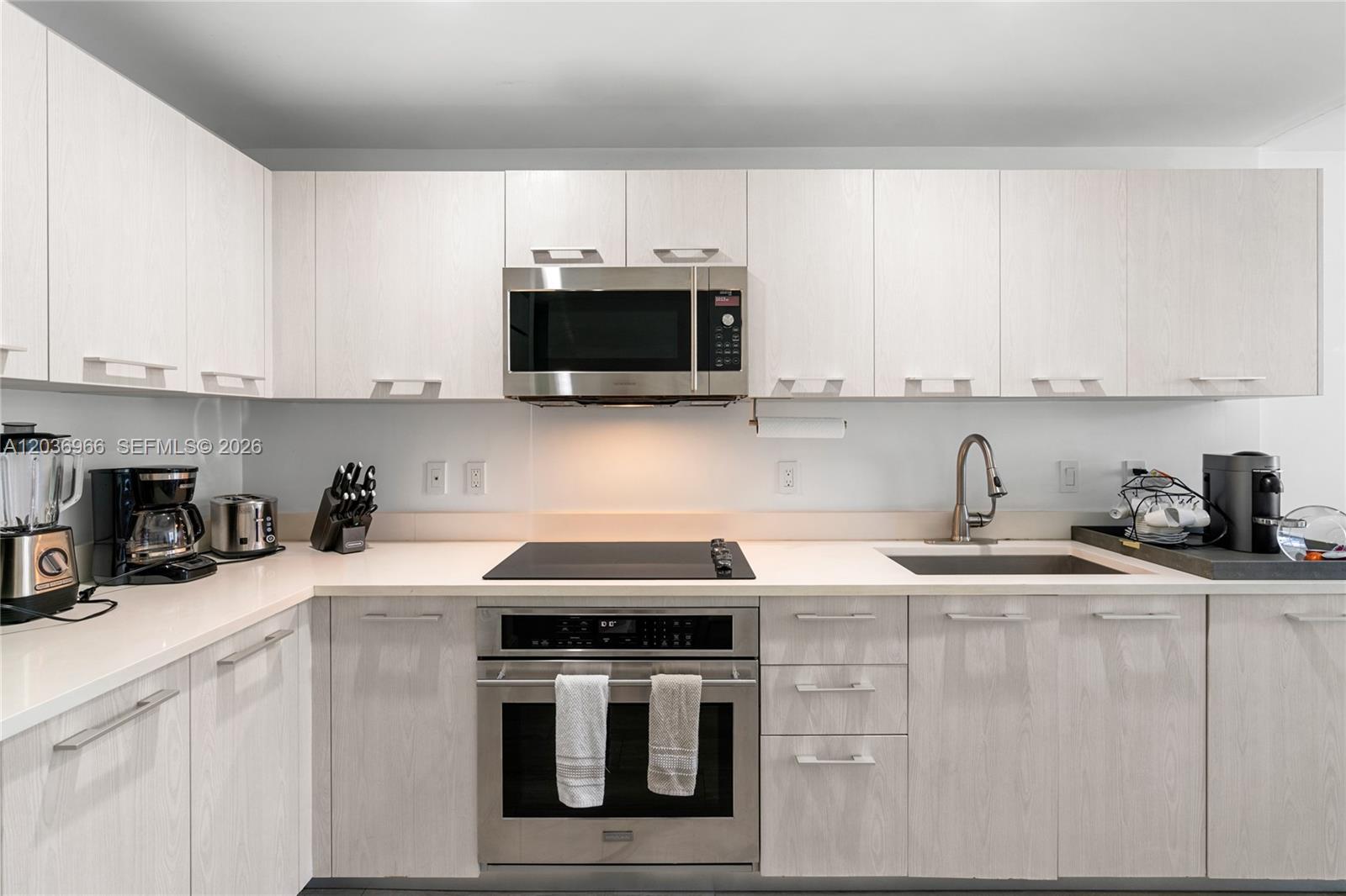 55 Southwest 9th Street, Unit 1904 Miami, FL 33130 - Photo 3 of 66 a kitchen with stainless steel appliances granite countertop a sink a stove a microwave and cabinets