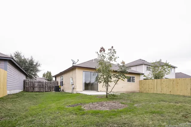 a view of a yard in front of a house with a large tree