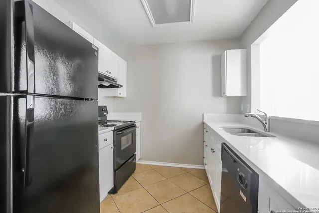 a kitchen with a sink a refrigerator and a stove