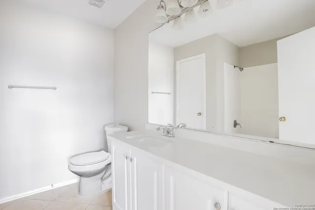 a bathroom with a sink mirror and toilet