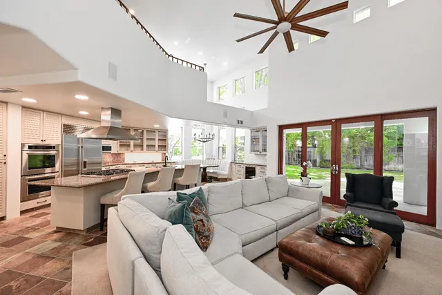 a living room with furniture a fireplace and a chandelier