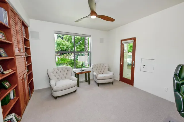 a bedroom with a bed flat screen tv and a large window