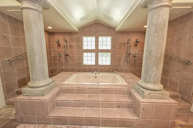 a bedroom with a bed and a dresser next to a window