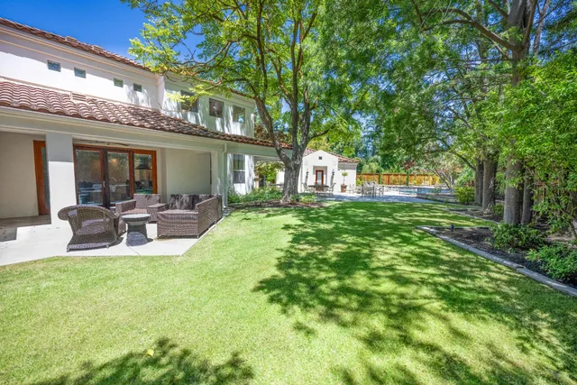 a front view of a house with a yard and fountain