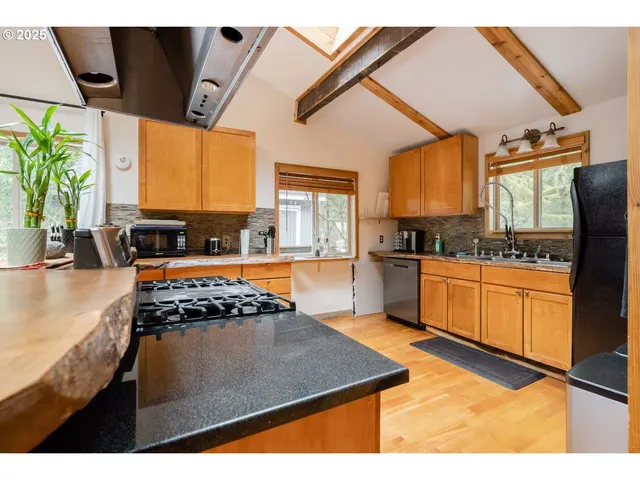a kitchen with stainless steel appliances granite countertop a stove a sink and a microwave