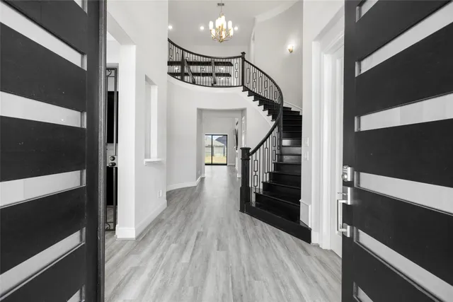 a view of a hallway with wooden floor and staircase