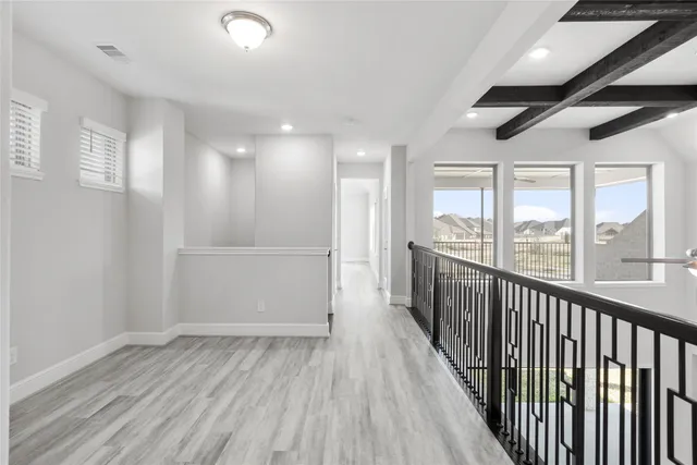 a view of hallway with wooden floor and windows