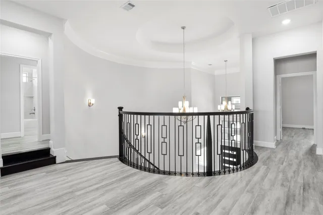 a view of a hallway with wooden floor and stairs