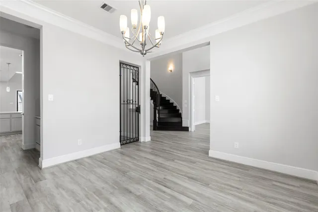 wooden floor in an empty room with a chandelier