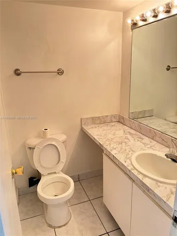 a bathroom with a granite countertop toilet and a sink
