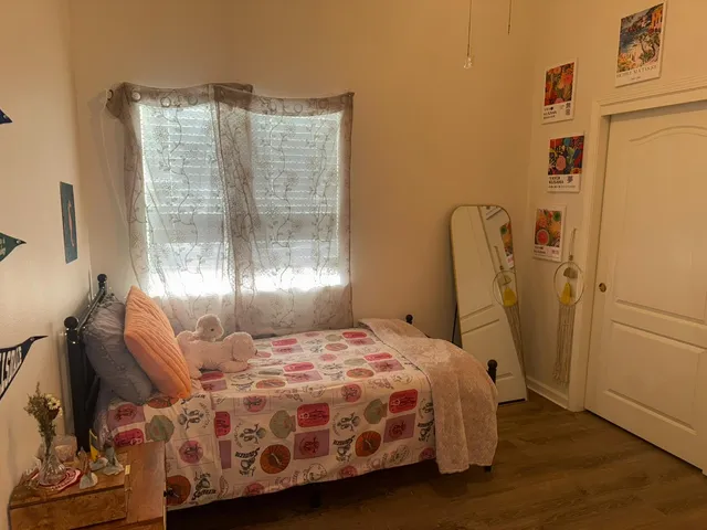 a bedroom with a bed and wooden floor