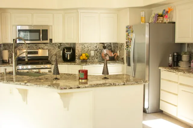 a kitchen with stainless steel appliances granite countertop a refrigerator and a sink
