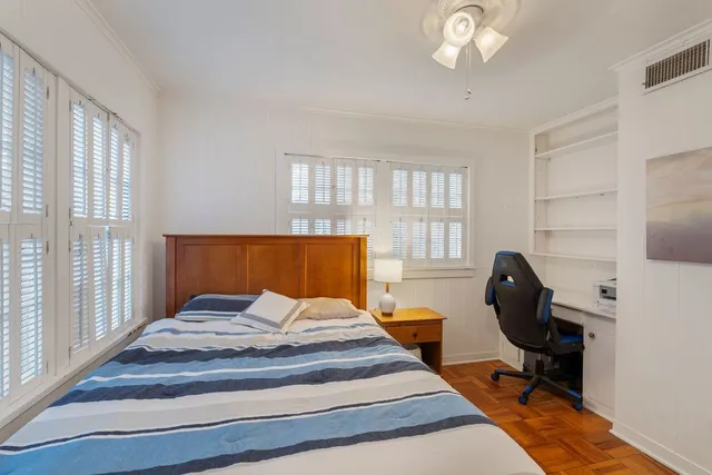 a view of a backyard with large trees and wooden fence