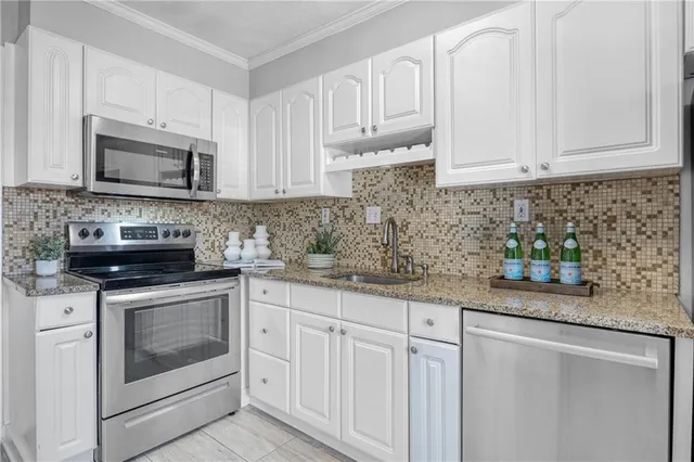 a kitchen with stainless steel appliances granite countertop a sink stove and microwave